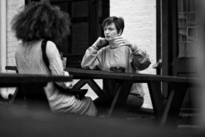two women at a table outside talking
